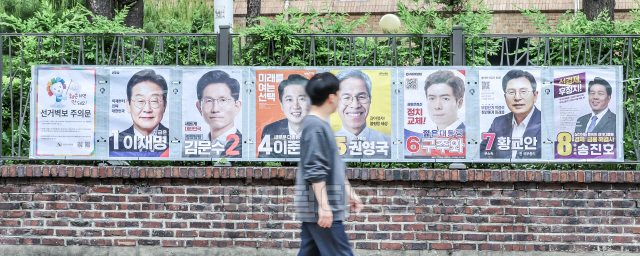 지난 15일 서울시선거관리위원회 관계자들이 서울 종로구 동숭동 예술가의집 담장에 게시된 제21대 대통령 선거 벽보를 살펴보고 있다.박동욱기자 fufus@